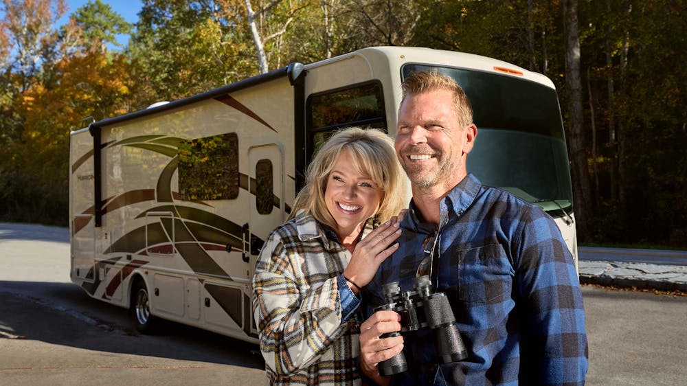 2022 Thor Hurricane Class A RV Lifestyle Tennessee Couple smiling motorhome centered behind Fall Leaves
