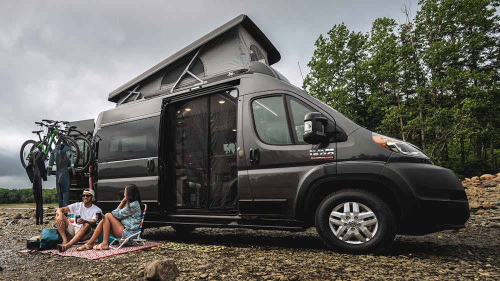 2022 Thor Scope Class B RV Camper Van Lifestyle Maine Corporate photo shoot at campsite couple seated slider size