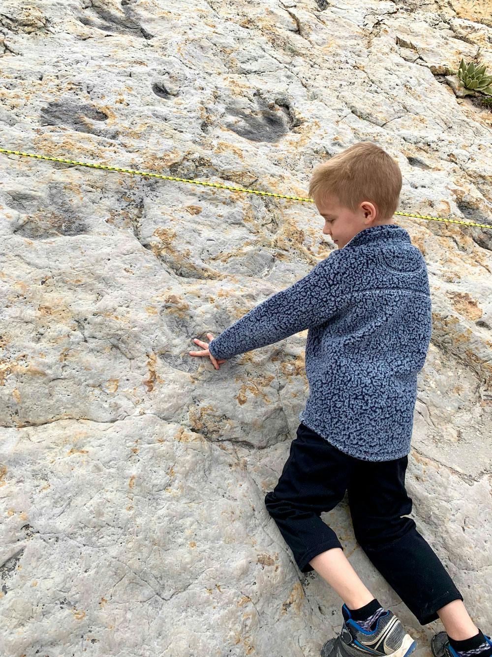 Blog Photo 7 Lessons Kids Learn Through RVing - exploring dinosaur tracks