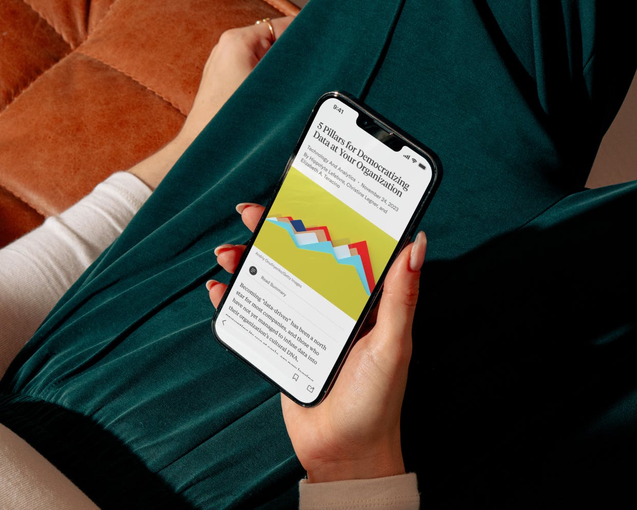 A person holding a phone with the Harvard Business review screen