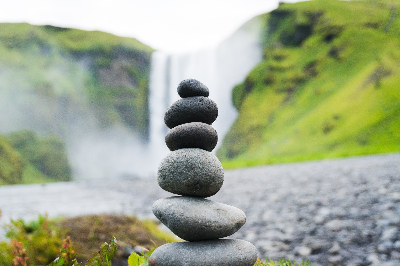 a cairn in front of a waterfall