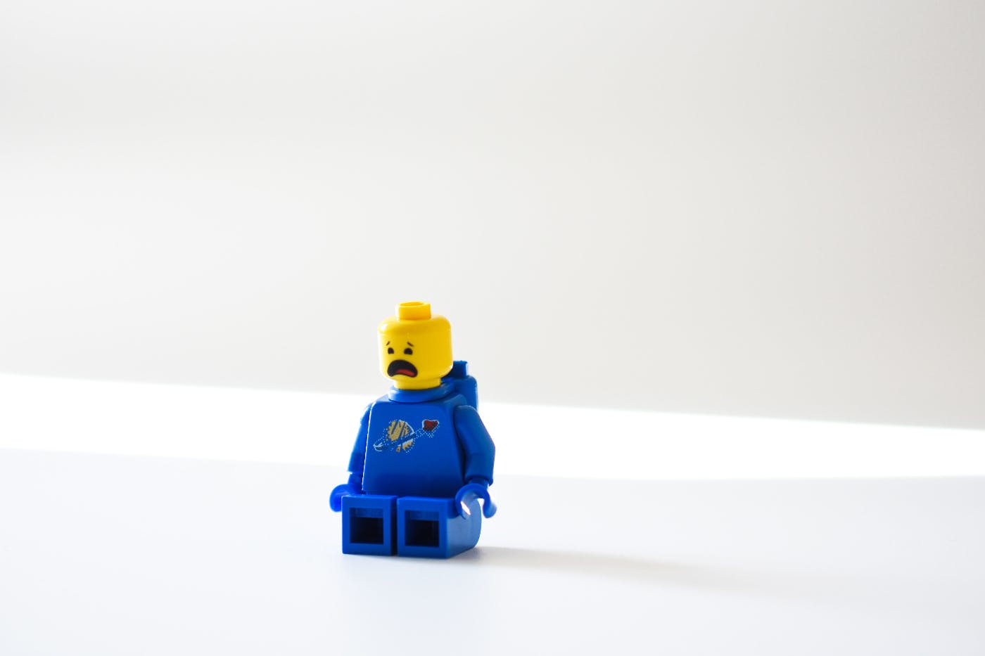 A tiny Lego person sitting and crying