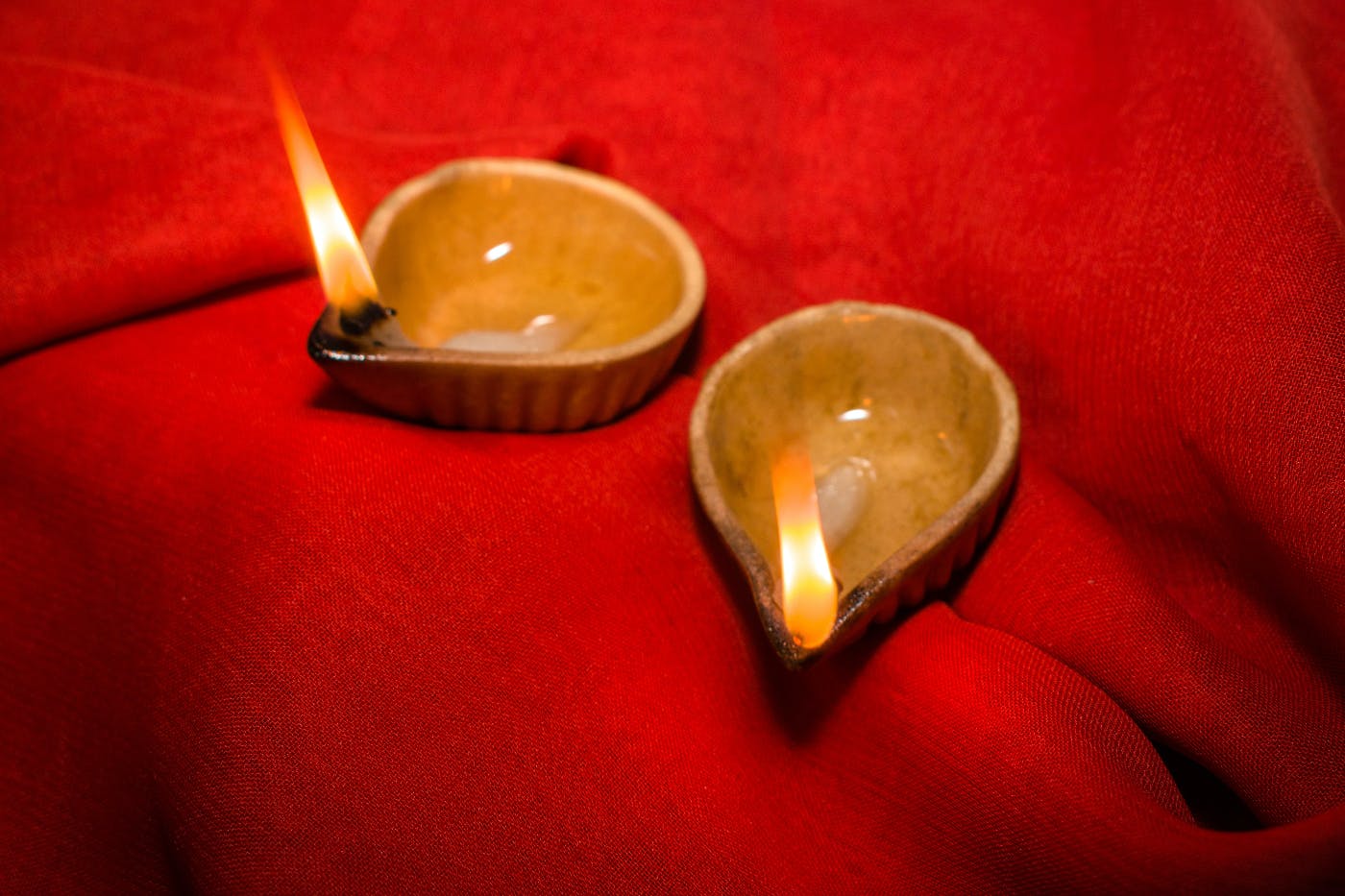 two candle bowls on red cloth