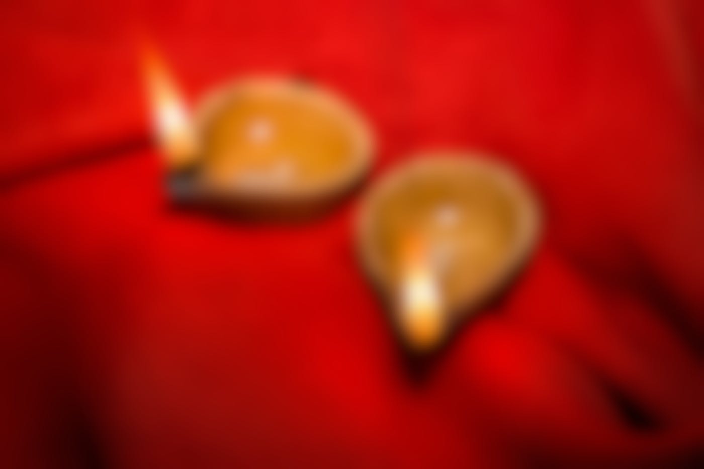 two candle bowls on red cloth