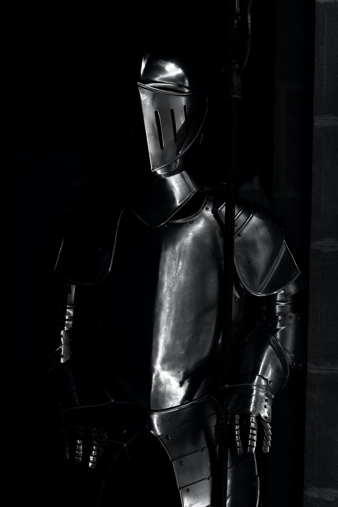 A man in a suit of armor lurking in the shadows