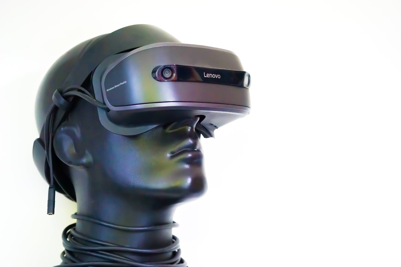 A silver mannequin head wearing a VR headset.