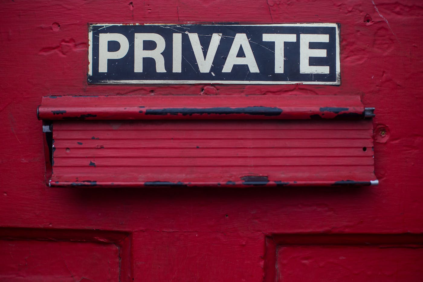  red door with a mail slot and a sign reading private