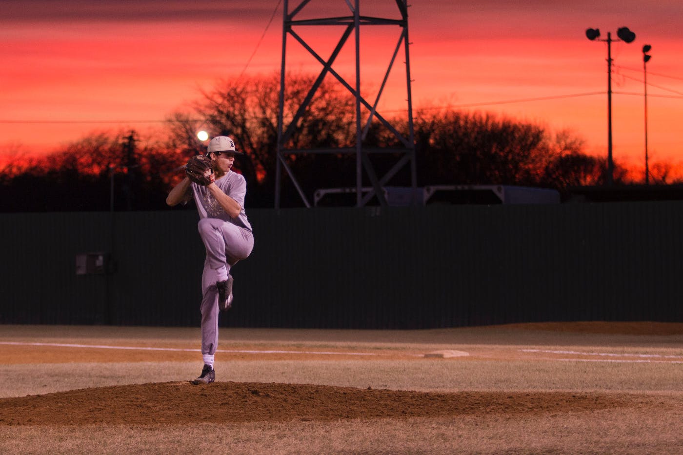 A baseball pitcher on the mound mid-wind up