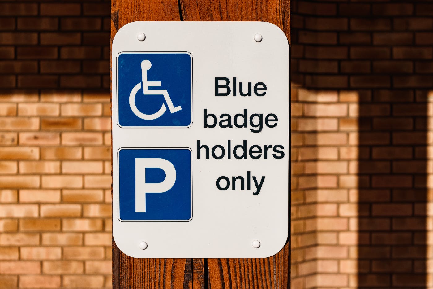 a sign reading blue badge holders only and the handicapped symbol