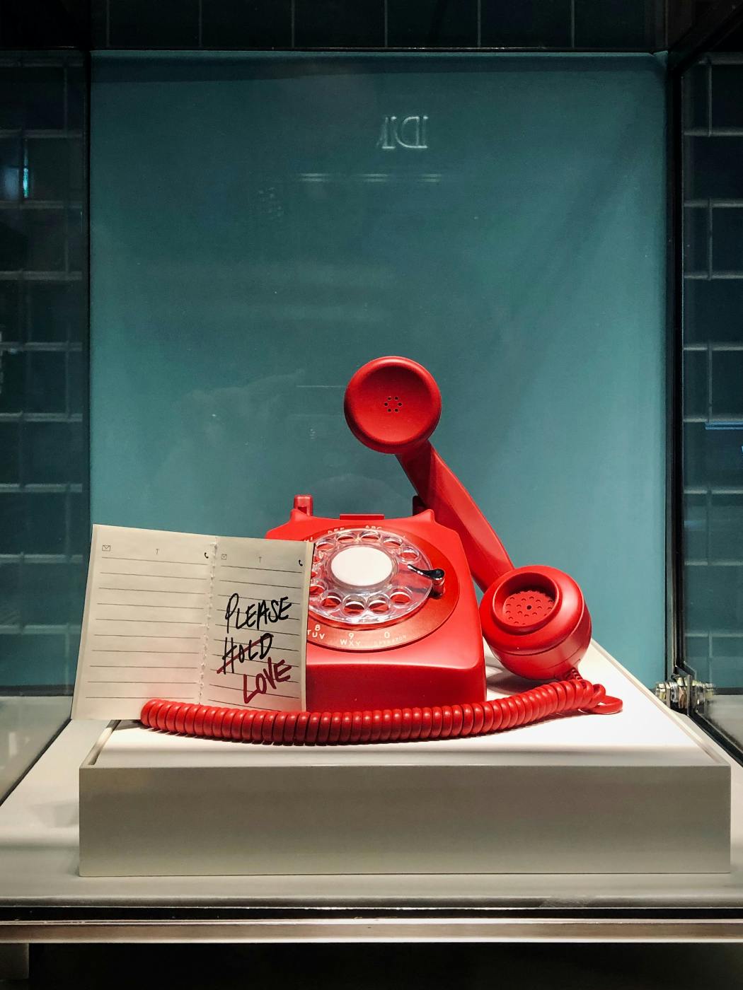 A red phone with a note rewading please love