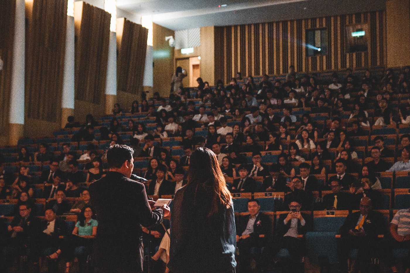Two people addressing a full lecture hall