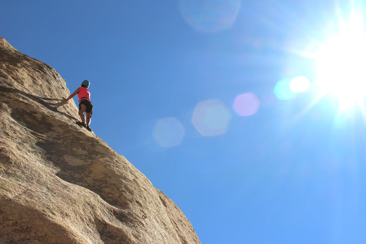 A woman ascending a very high rock formation