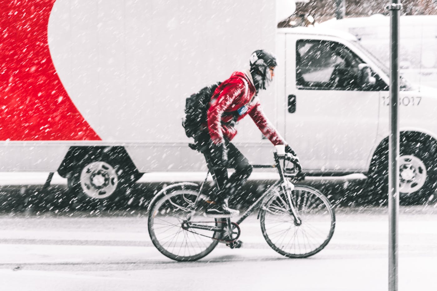 A man riding his bike in a snowstorm