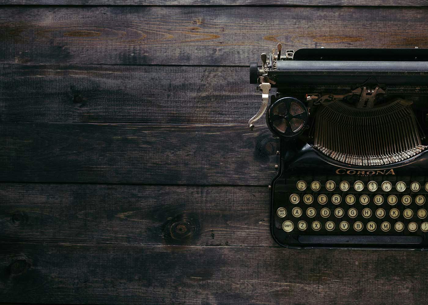 Old black typewriter on a wooden desk