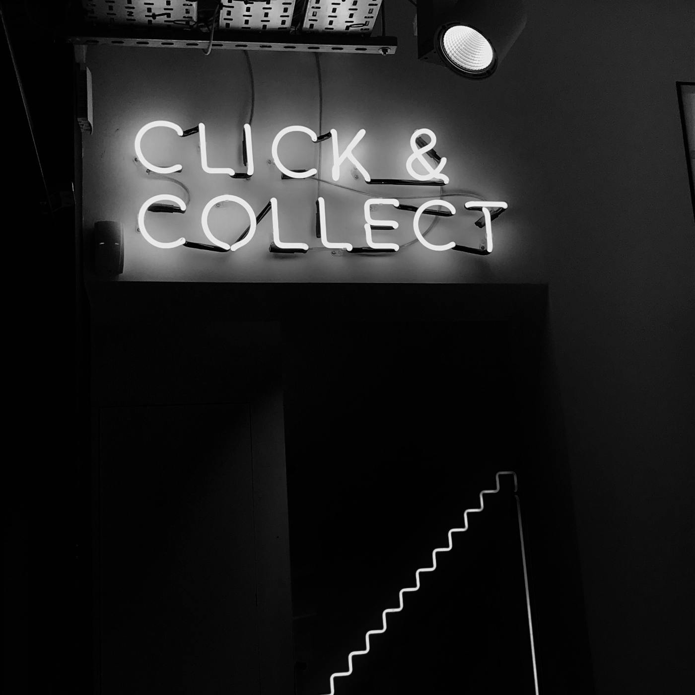 a black and white image of a neon sign that reads click & collect