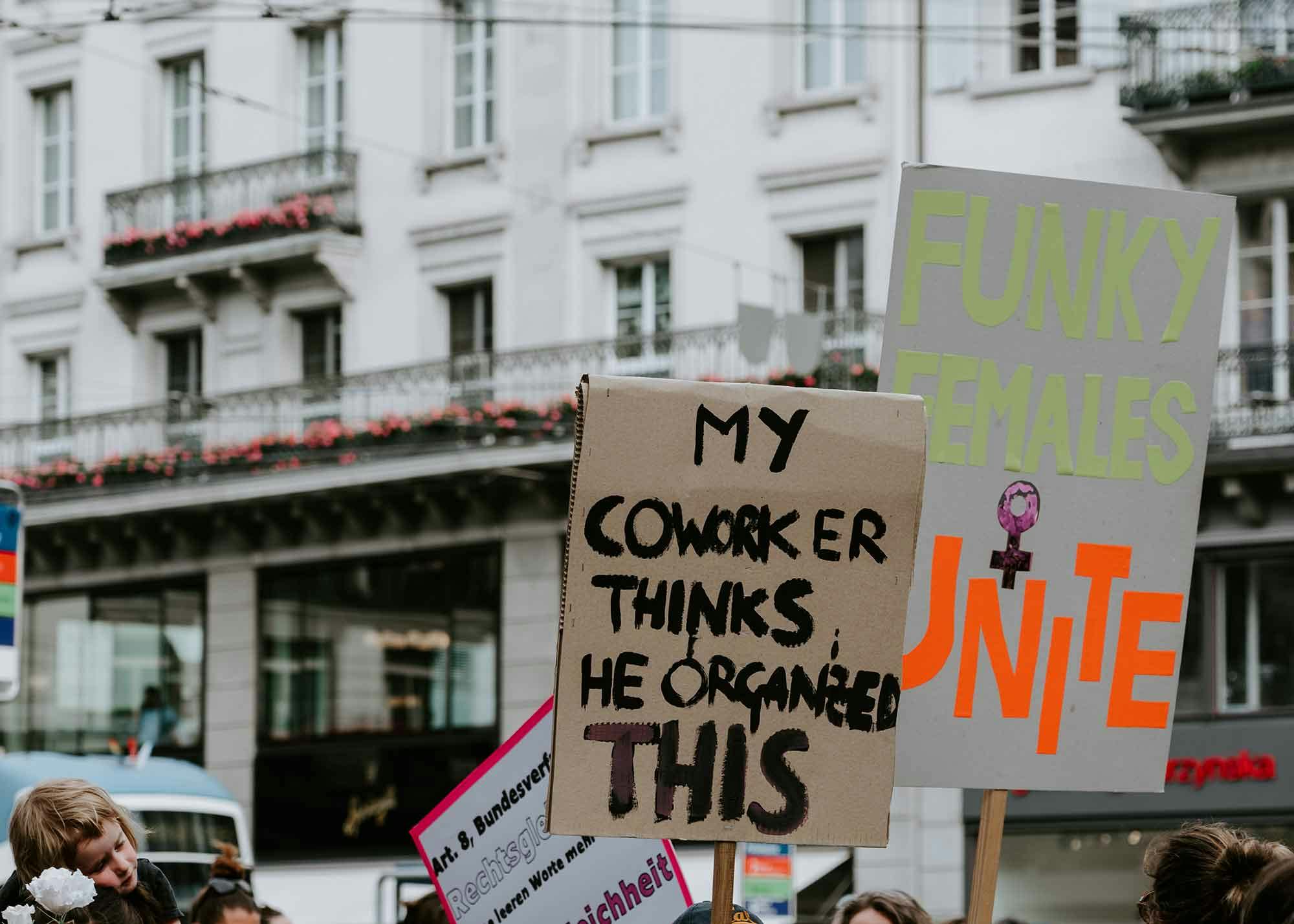 A protester holding a sign that says "My coworker thinks he organized this"