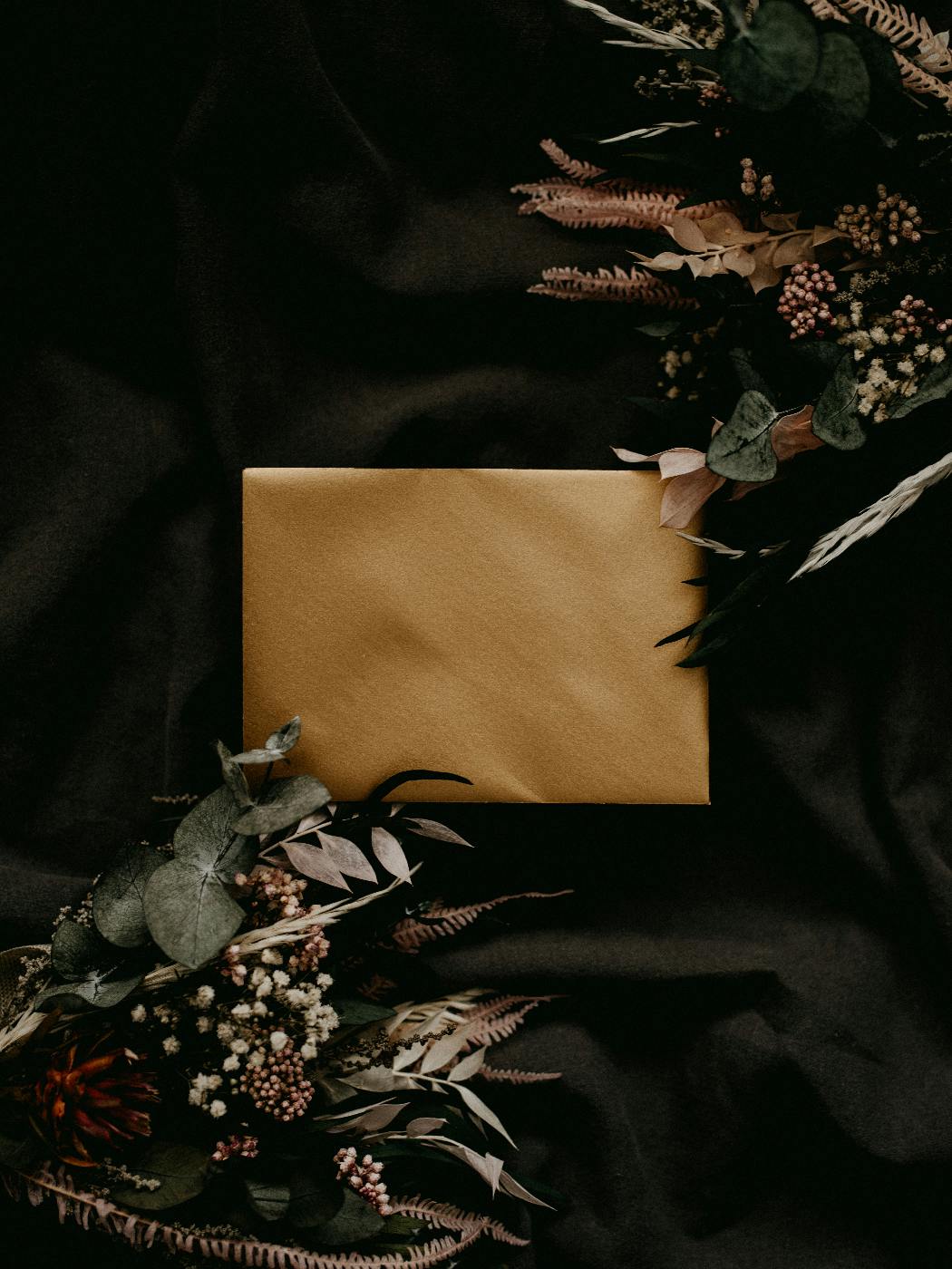 A brown paper package in a black backdrop with flowers