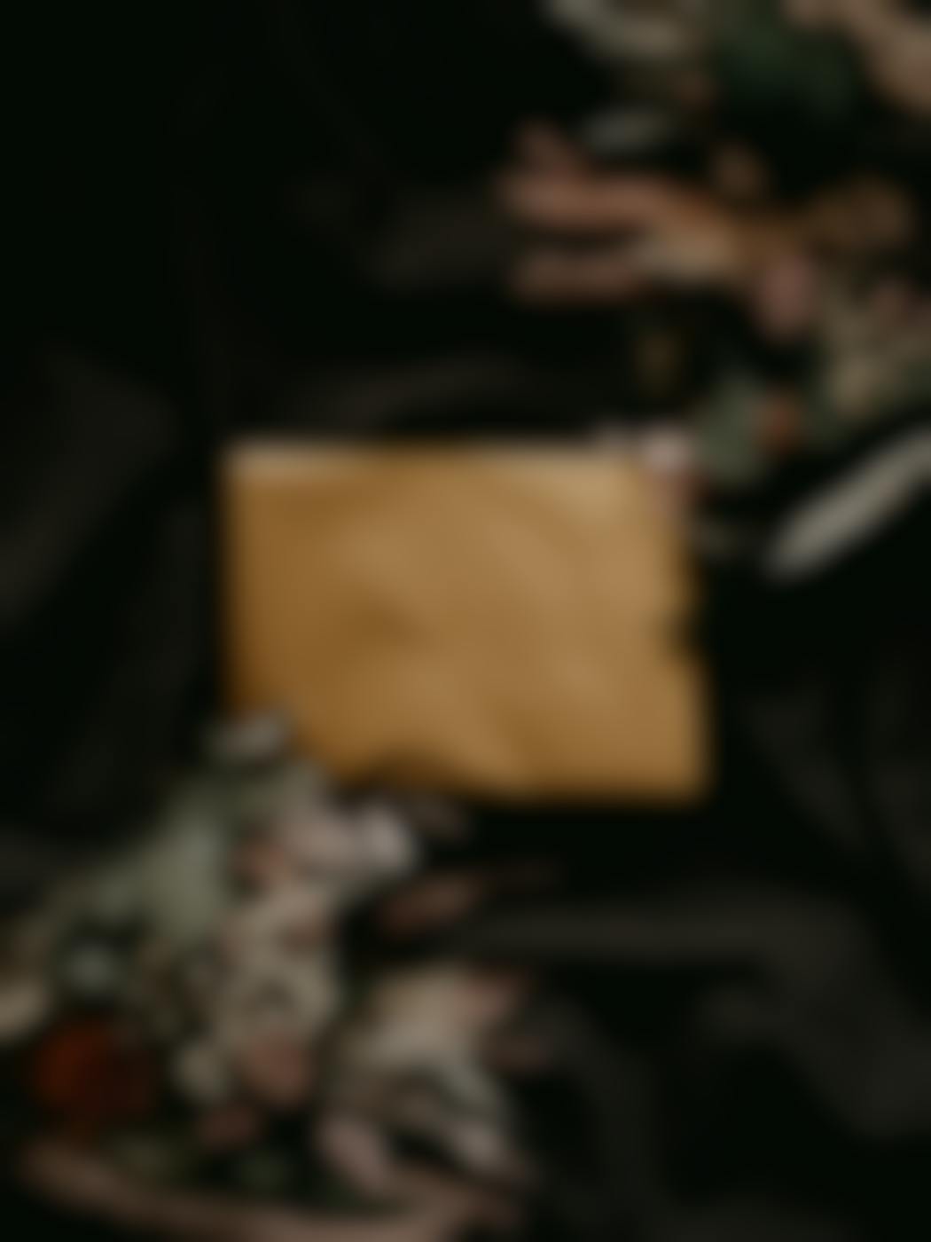 A brown paper package in a black backdrop with flowers