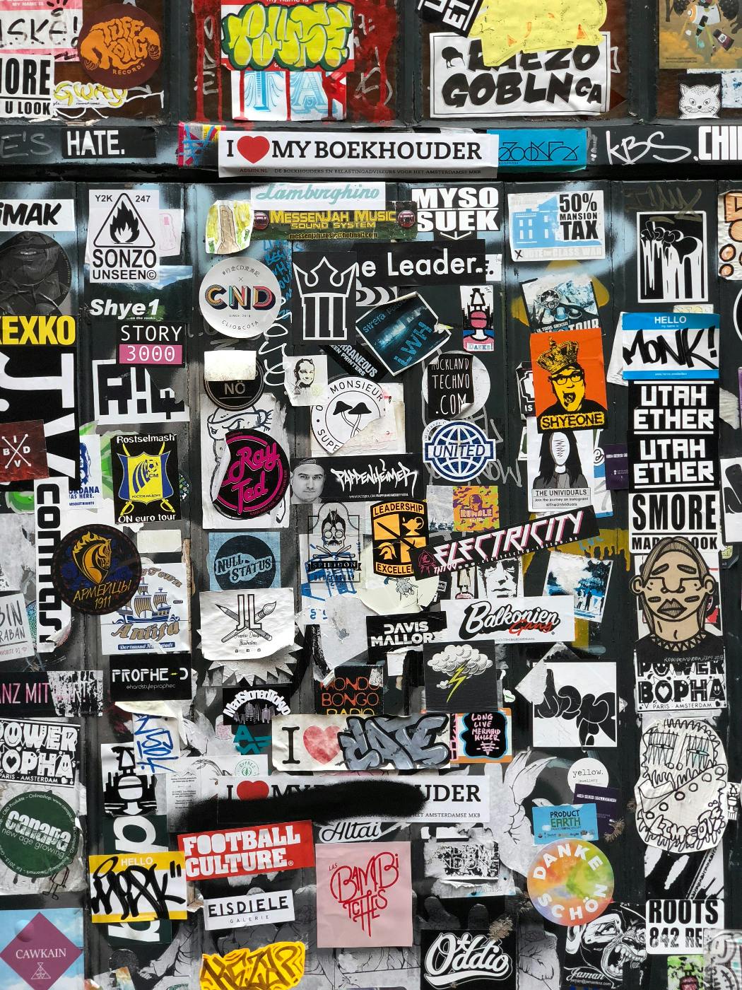 A wall covered in stickers for various brands