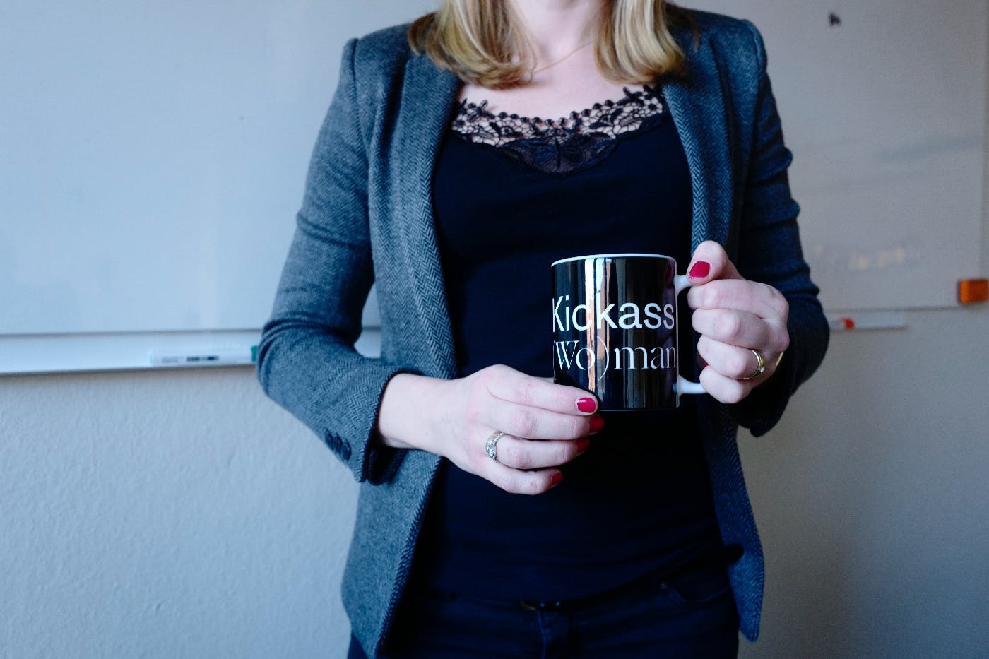 A woman holding a coffee mug that reads Kickass woman