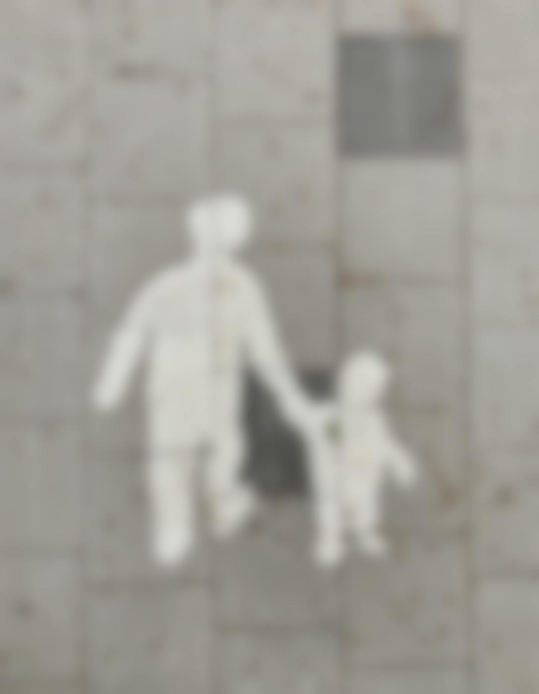 A painting in the sidewalk, outline of an adult holding  a child's hand