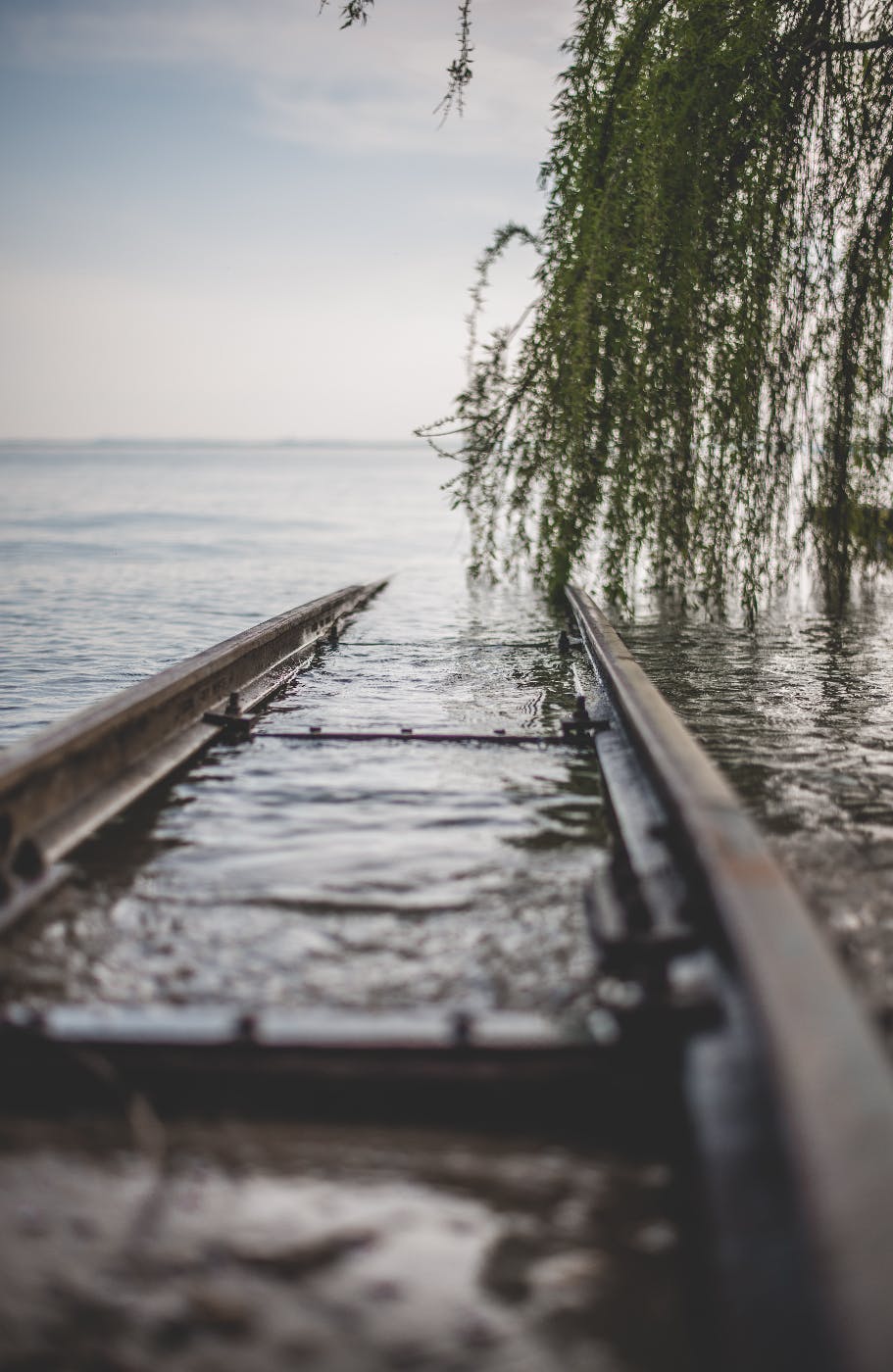 train tracks ending in a lake