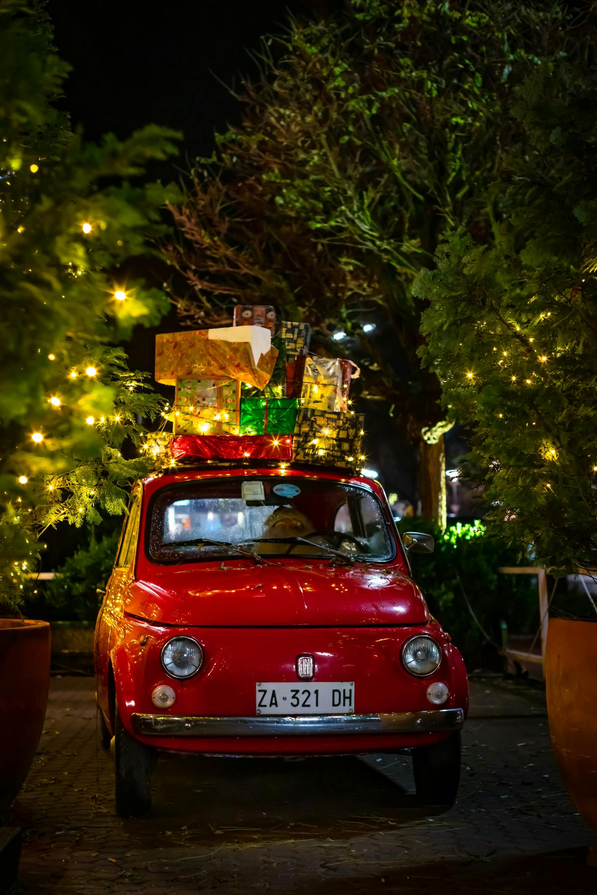 A red Fiat loaded up with brightly wrapped Christmas gifts.