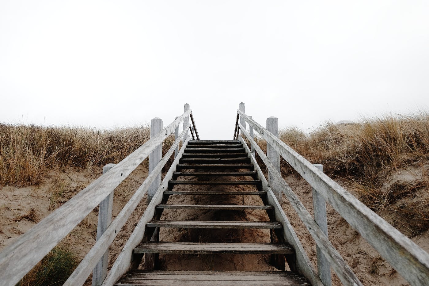 a staircase over a sand dune