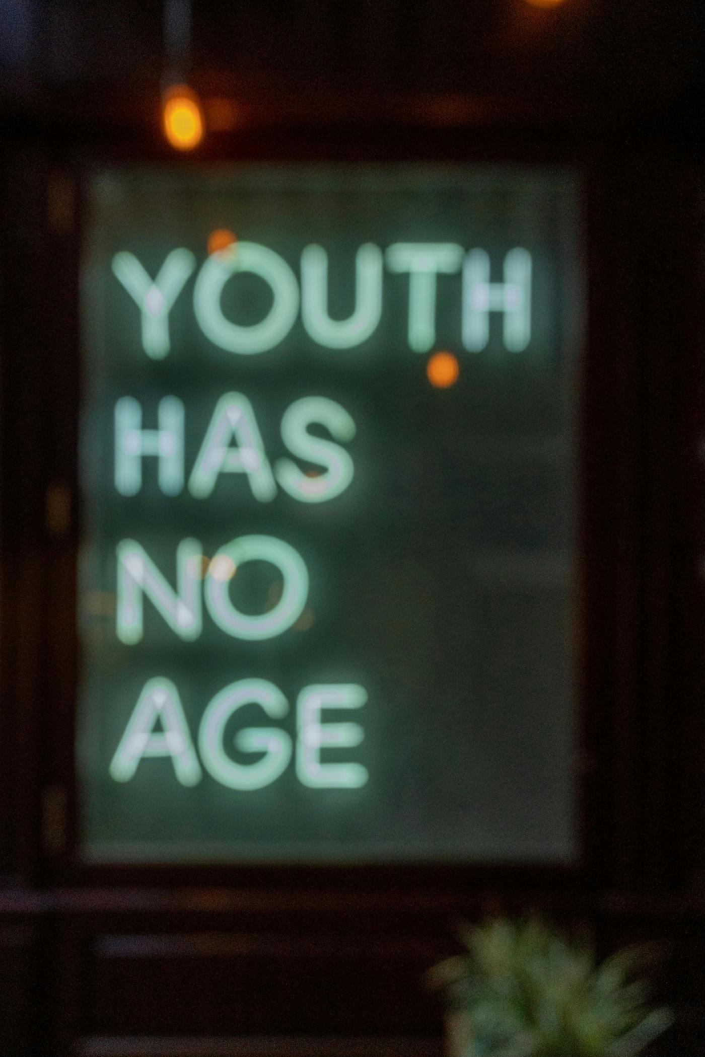 a neon sign reading Youth Has No Age