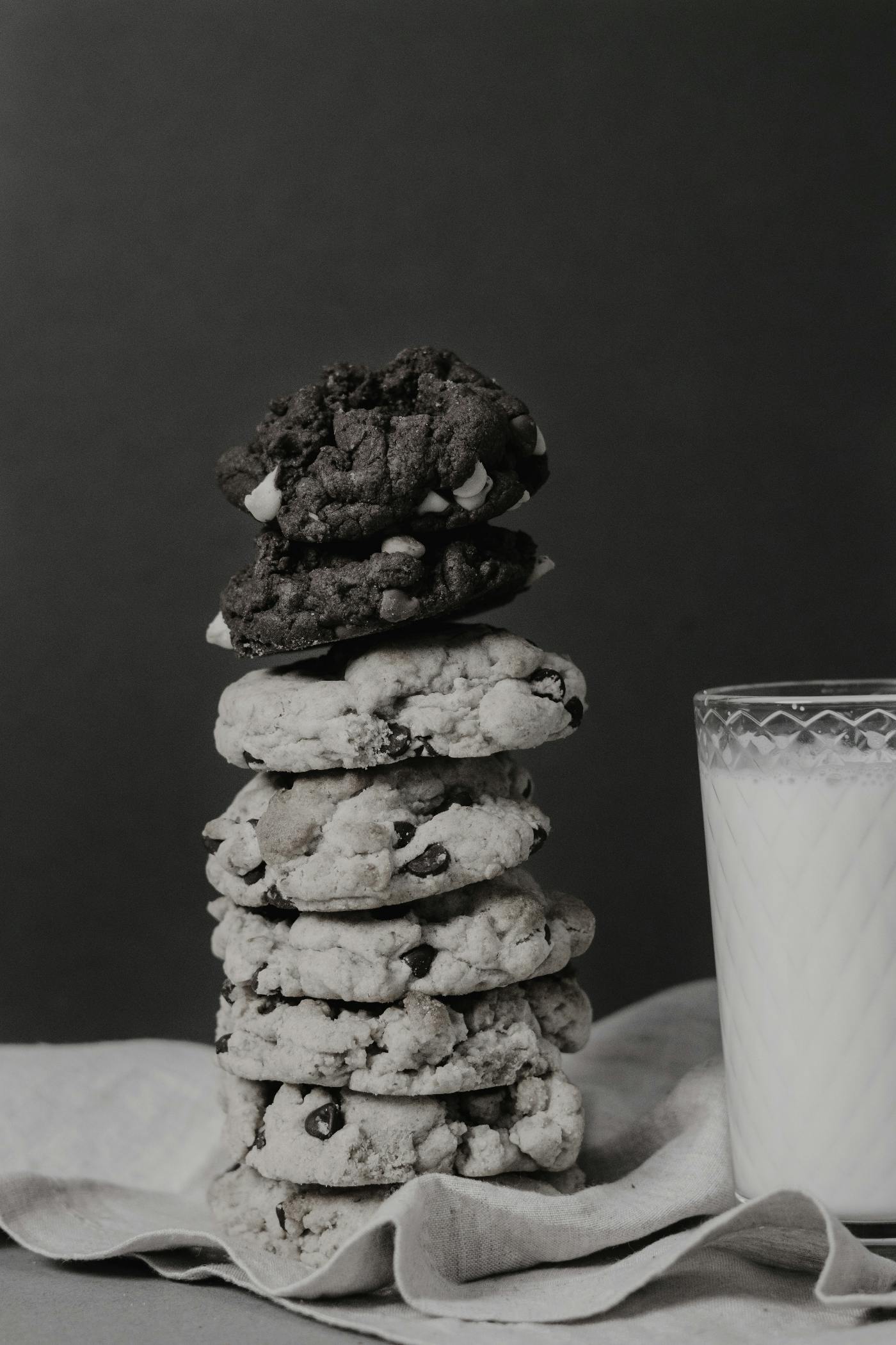 A stack of cookies next to a glass of milk