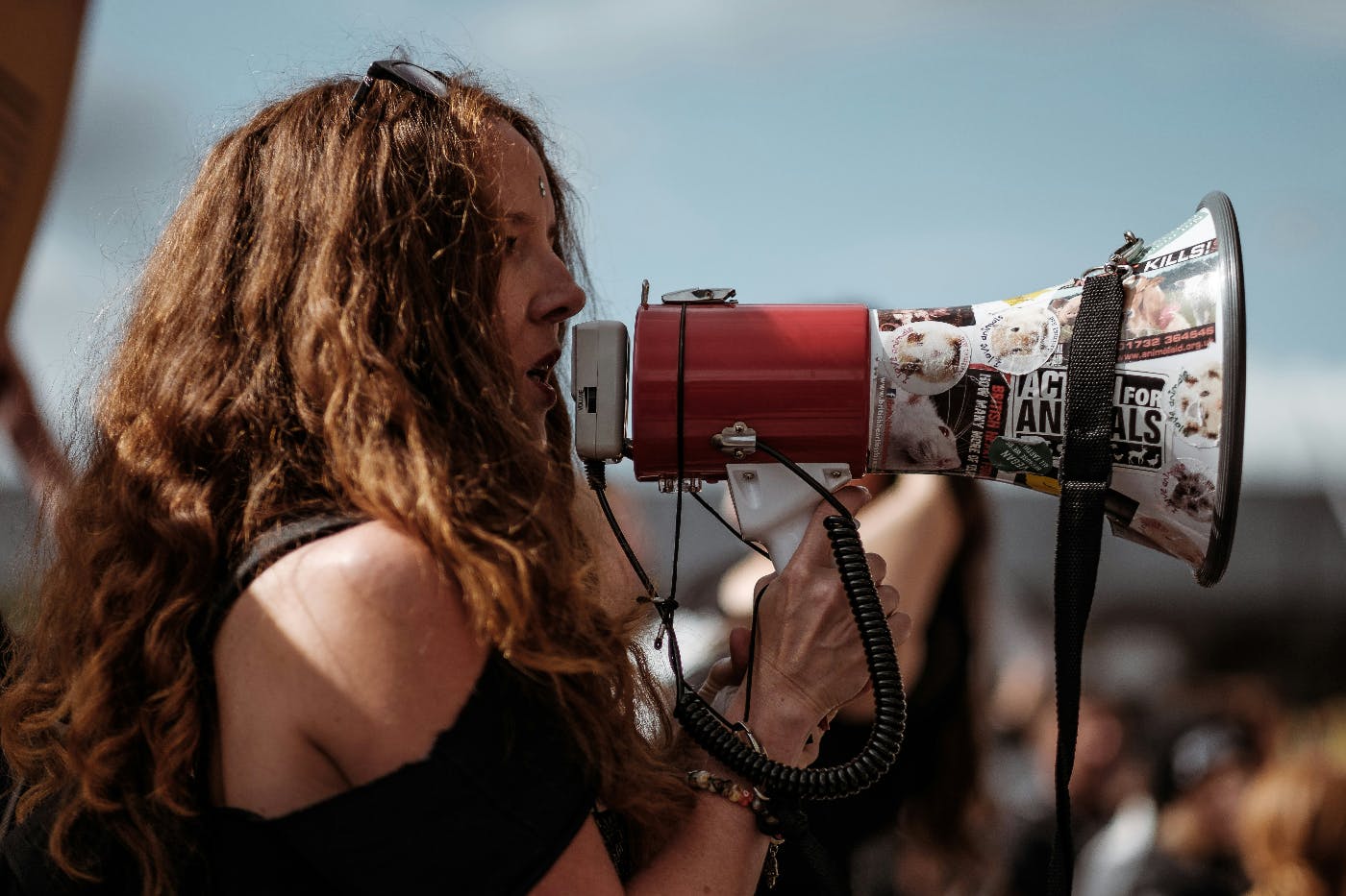 A woman at an outdoor rally using a bullhorn