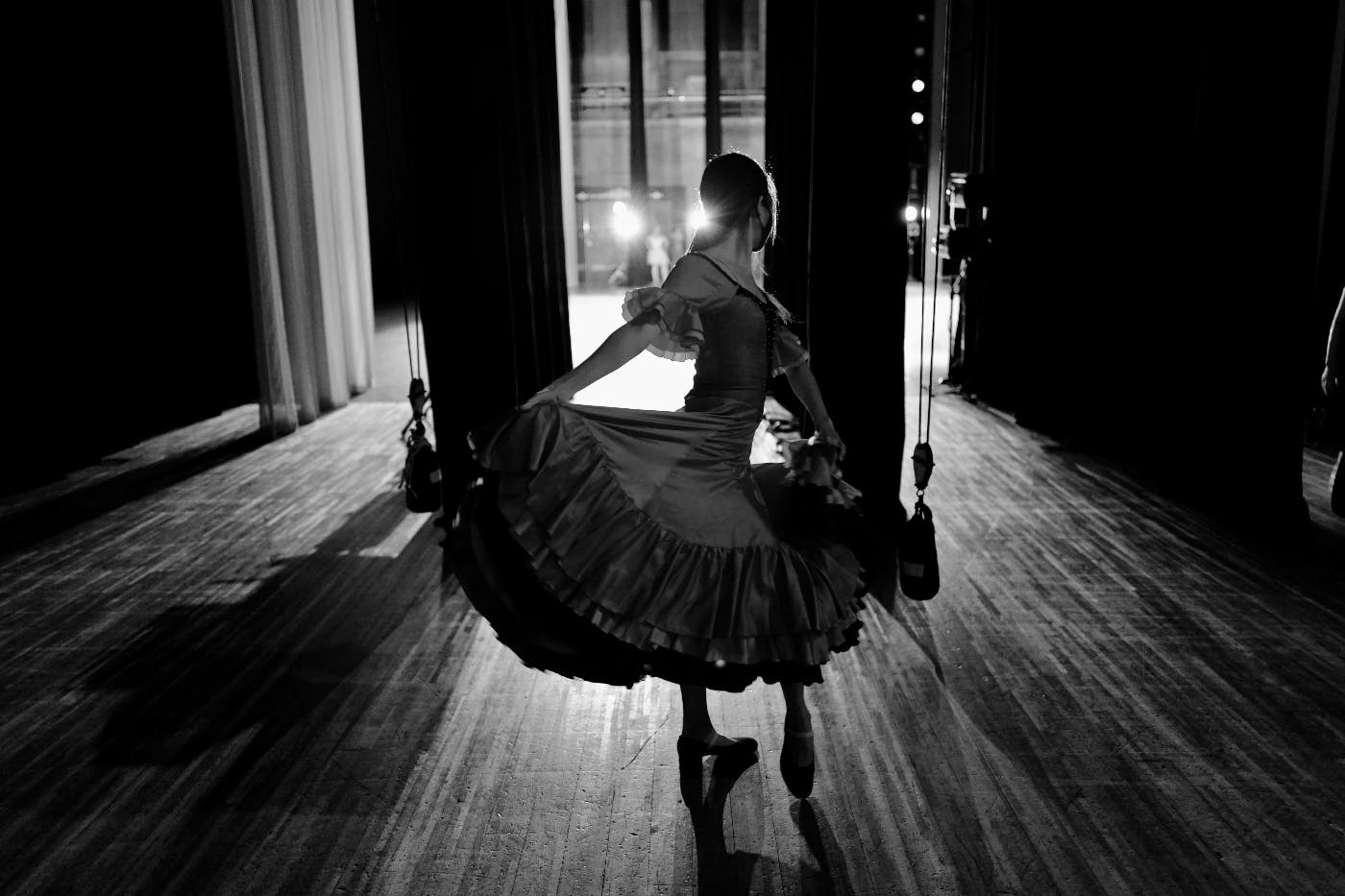 A female flamenco dancer, posed in the wings, waiting to go on stage