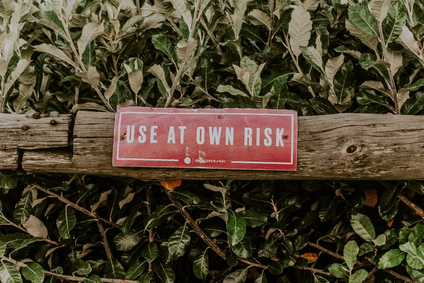 A wood fence with a sign reading Use at own risk