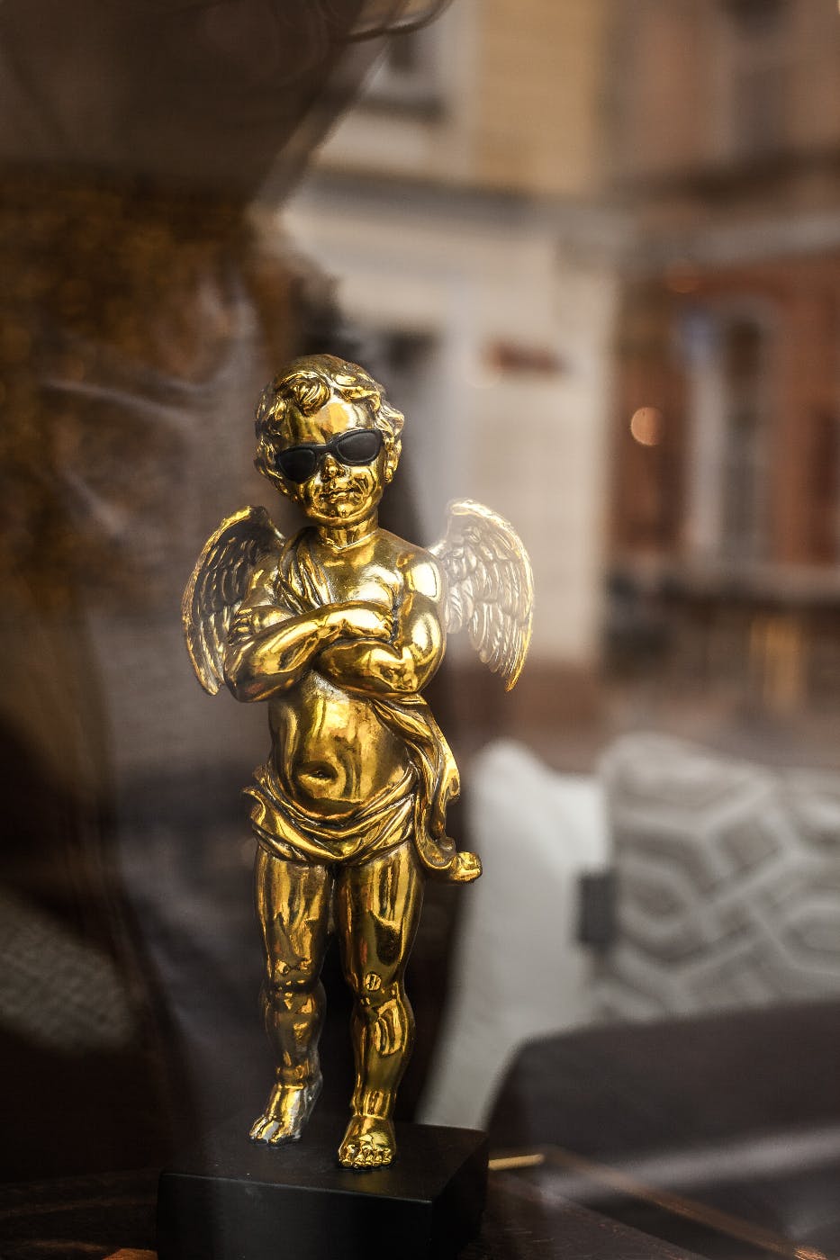 A gold statues of an angel wearing dark shades