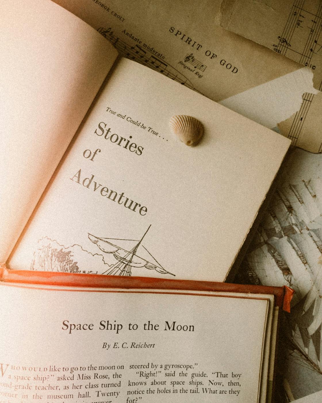 Open books, Stories of Adventure, Space Ship to the Moon and a sea shell