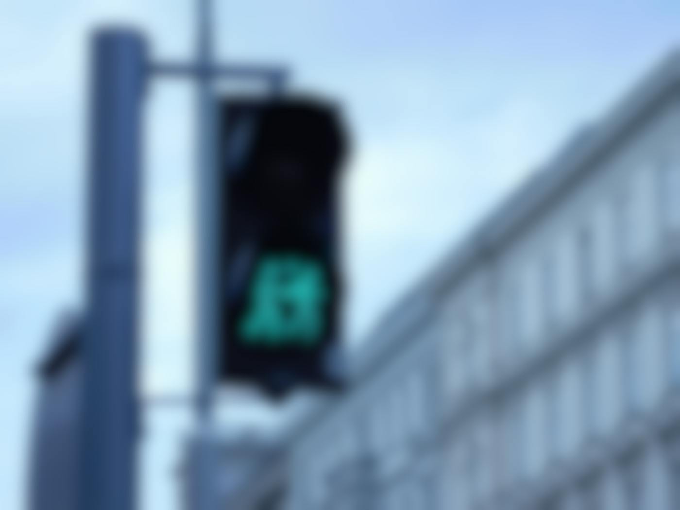 A traffic light with the bottom light displaying a couple holding hands and a heart between them.