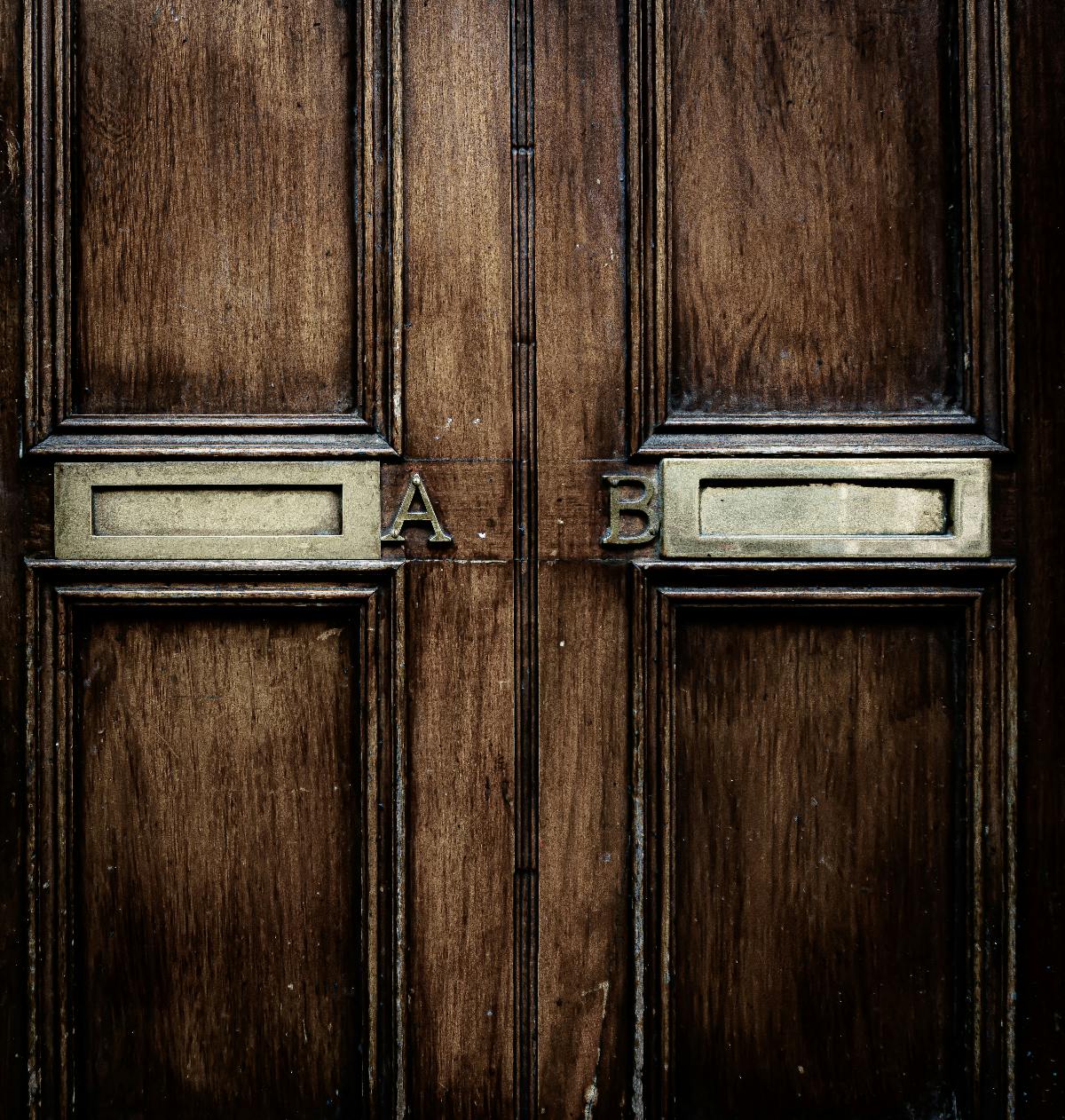 Two brown doors, identical except the one on the left  has a Silver A the one on the right has a silver B