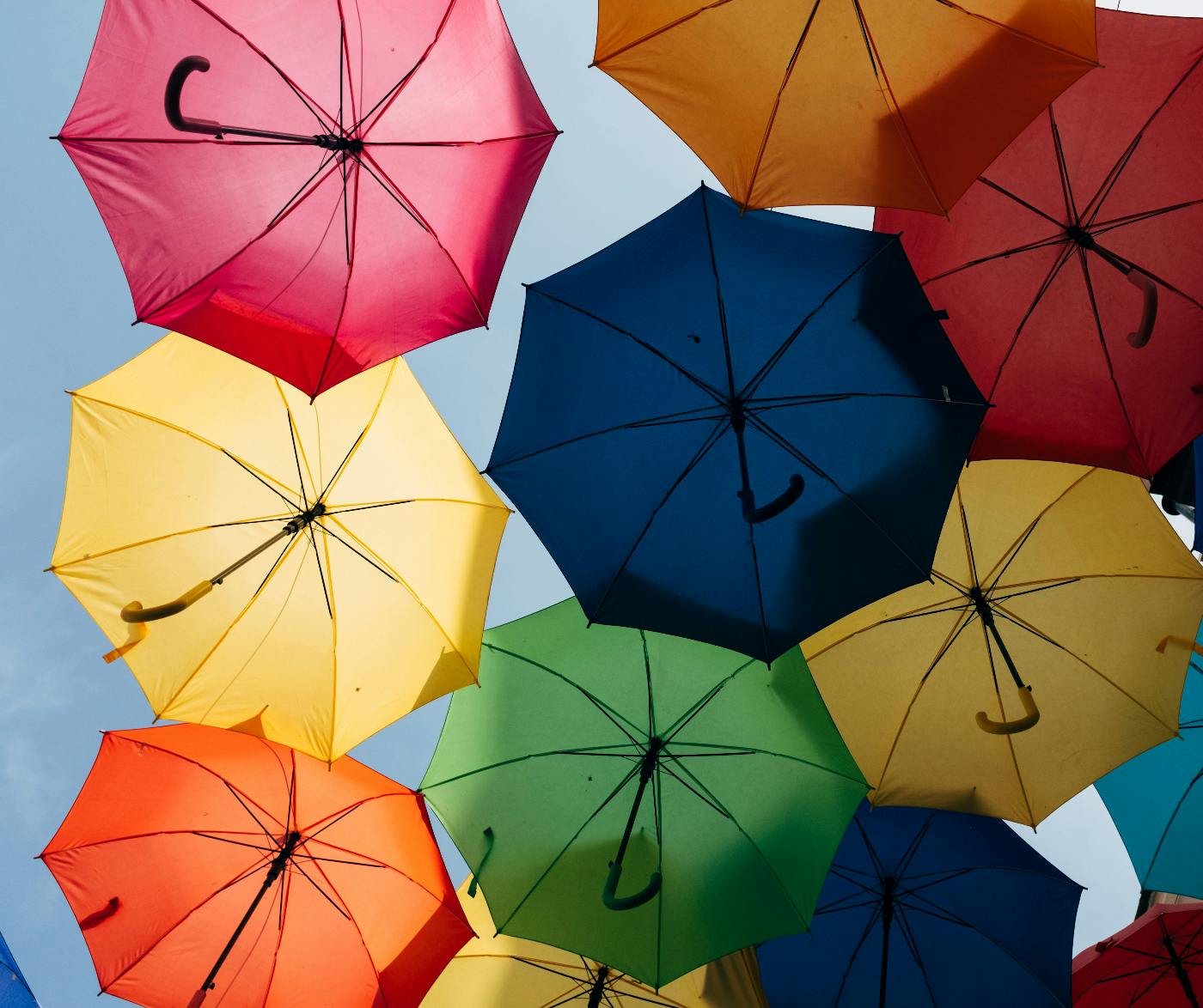 A view from under multi colored umbrellas floating