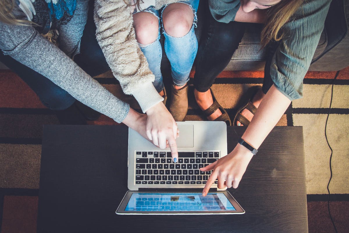 Three people looking at an advertisement on a laptop screen