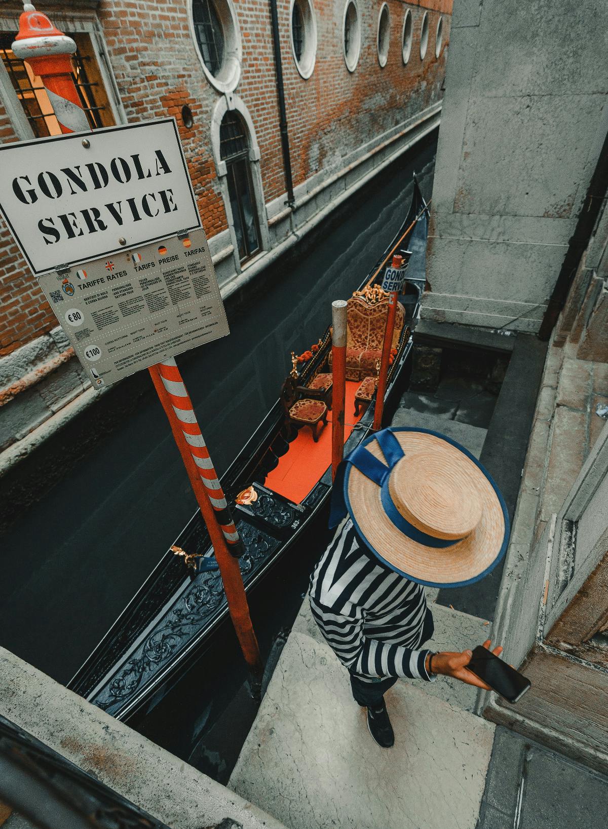 A Gondolier using a cell phone with his back to the Grande Canal in venice