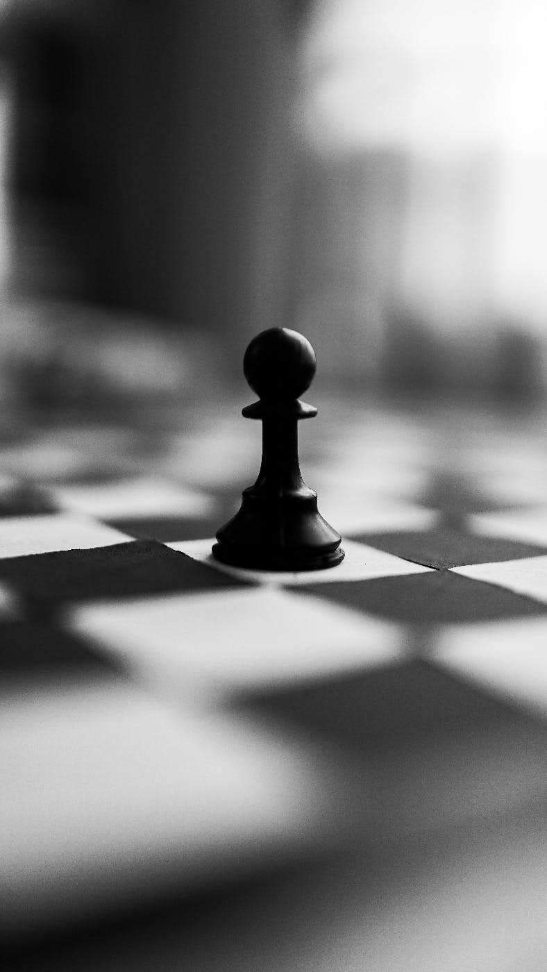 A chessboard with a black pawn on a white square