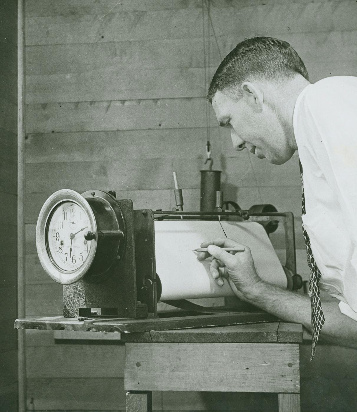 greyscale, a man marking with a pencil on a graph