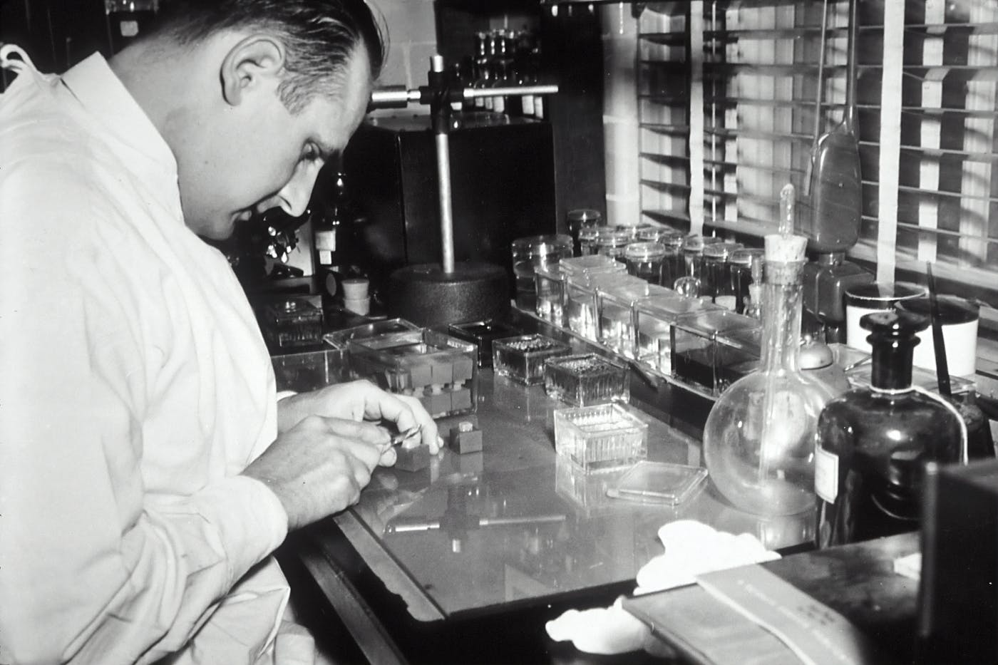 A grayscale image of a man working  in a lab in 