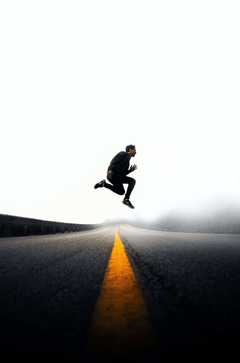 man in mid air jumping over a finish line