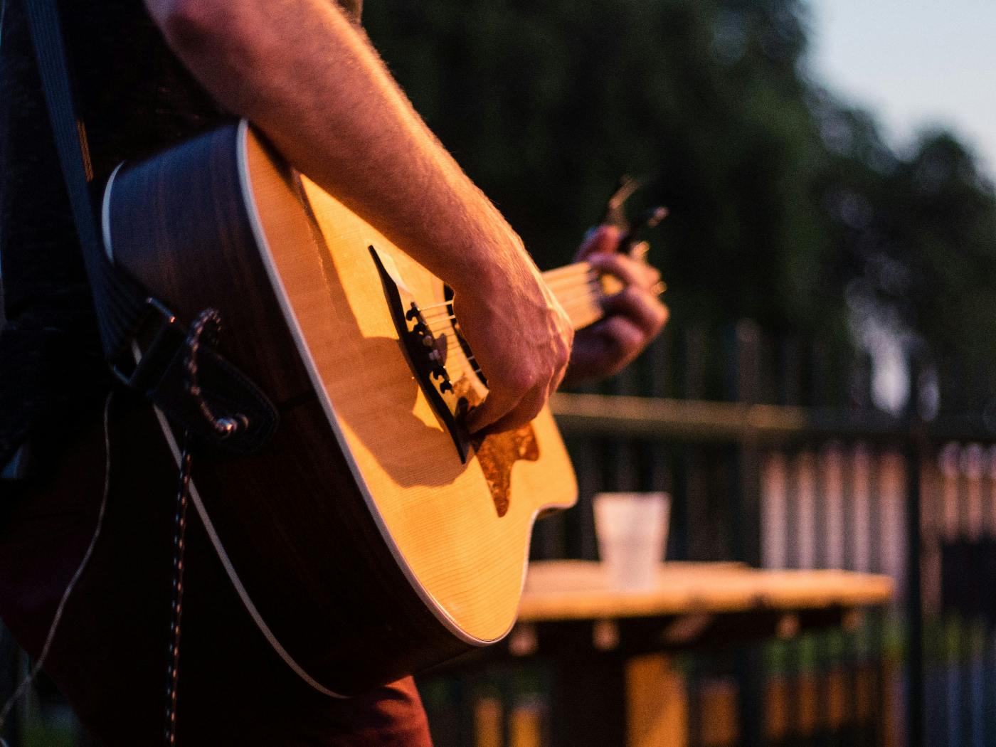 A man playing guitar on an outdoor patio