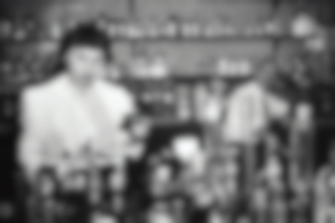 a black and white photo of a male and female scientists working with tubes, pills and bottles.