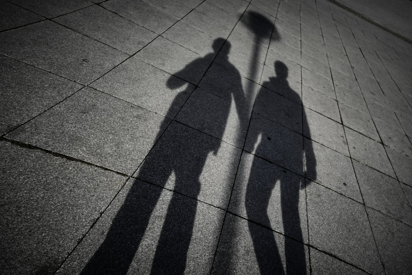the shadows of two people holding hands