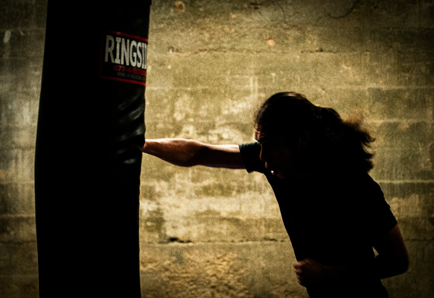 a man hitting a heavy boxing bag