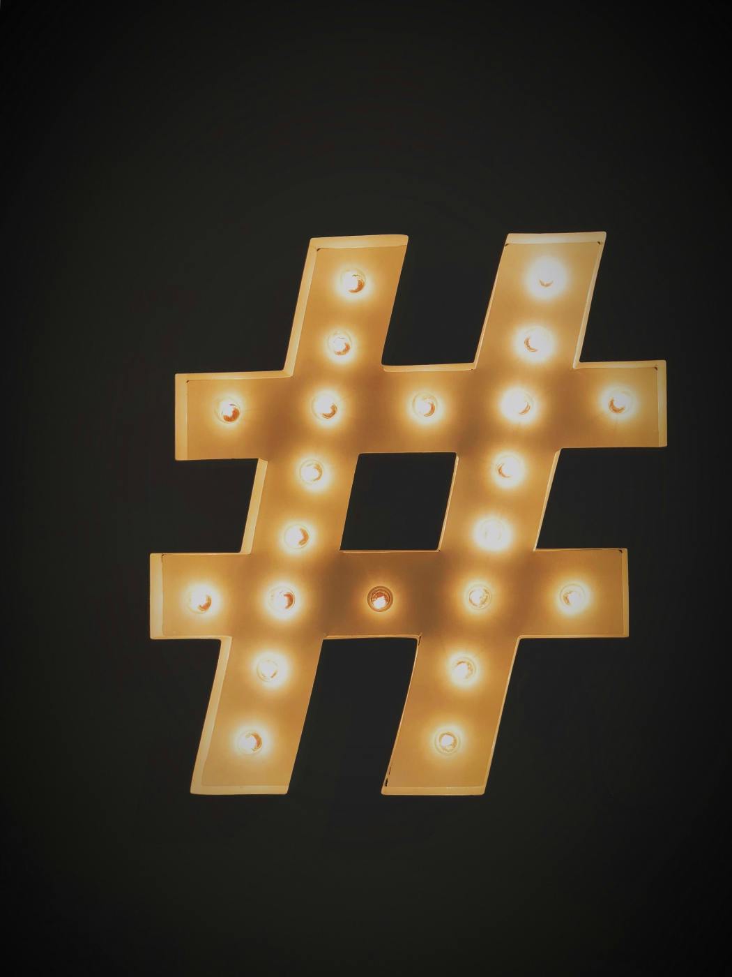 a gold hash tag with light bulbs in it