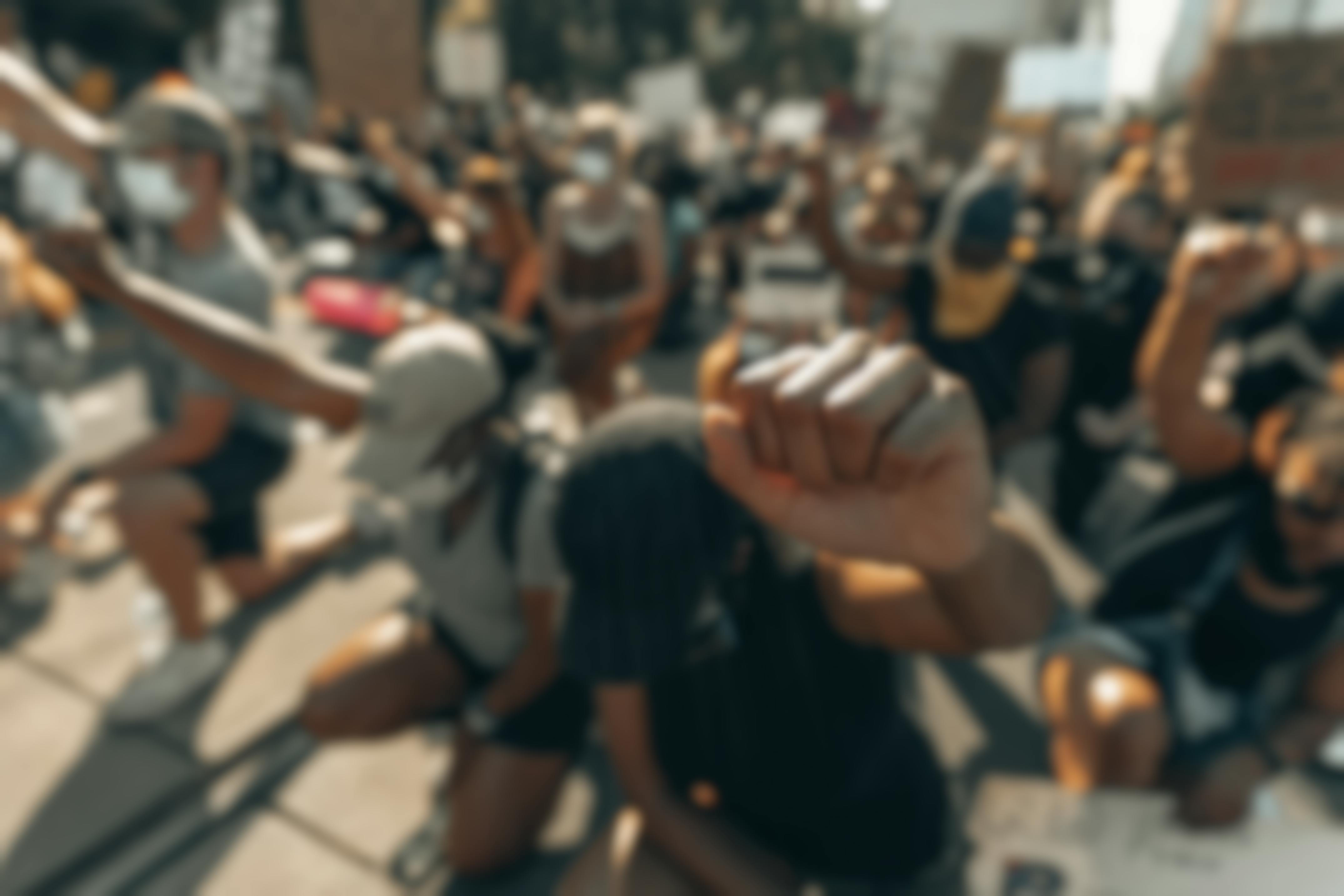 protestors kneeling with fist in air